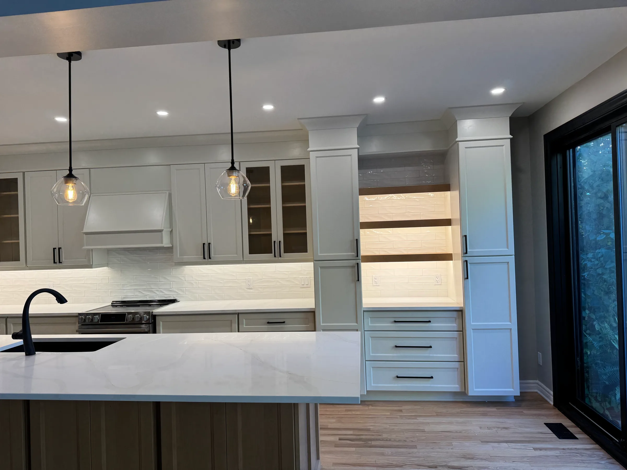 Custom kitchen cabinetry with glass-front uppers and a built vent hood surround, Ottawa